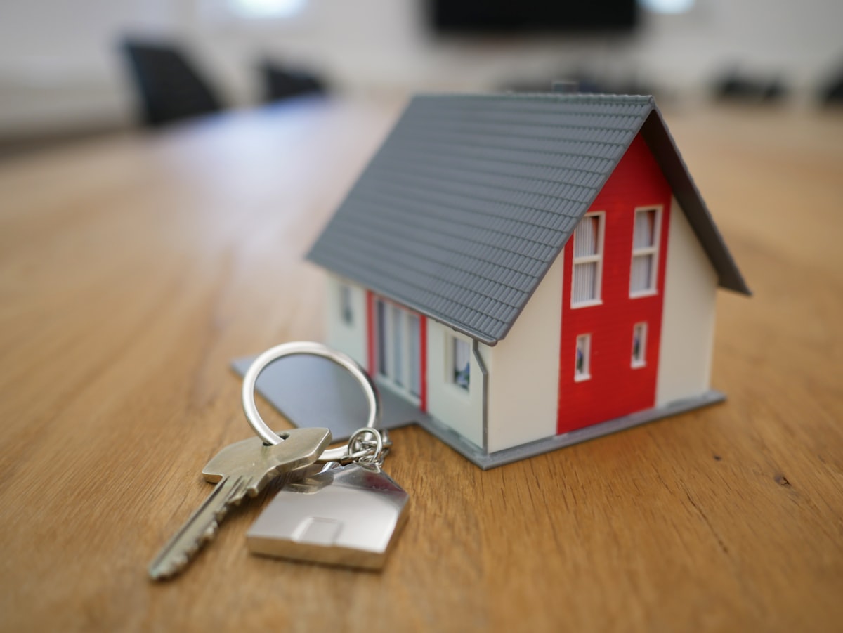 Model house with keys on a table, representing property purchase decisions and pricing discussions
