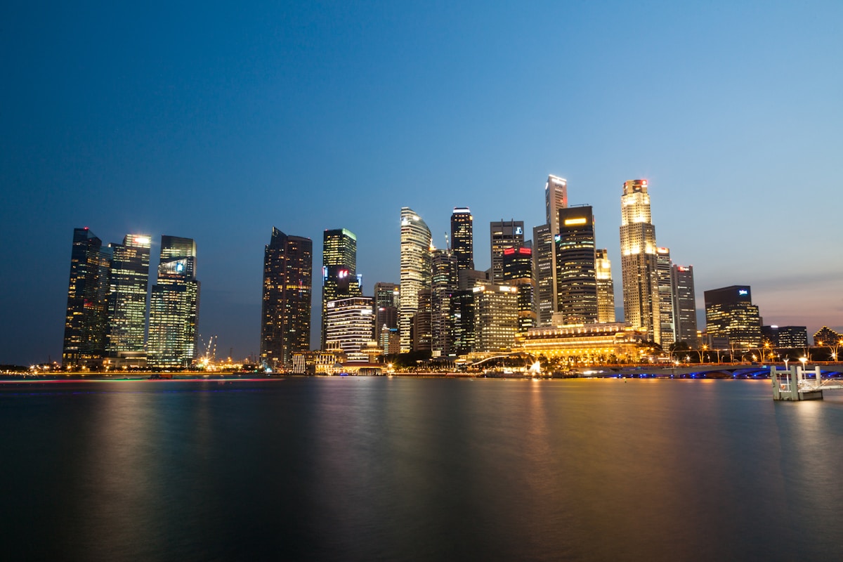 Singapore CBD skyline at dusk with Grade A office towers reflected in Marina Bay water, representing the 2026 office market signals for residential property agents