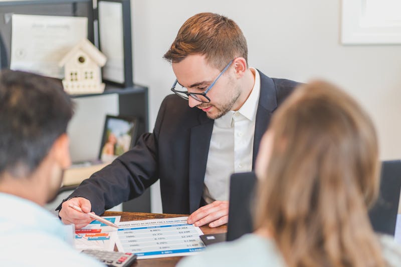 Property agent discussing floor plans with clients at a showflat