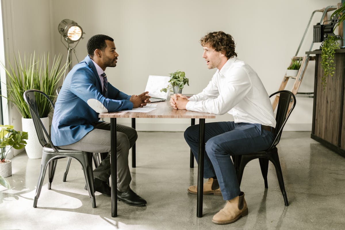 Singapore property agent in a serious consultation conversation with a client across a meeting table